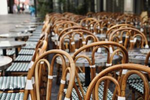 Sillas apiladas sobre las mesas de una terraza cerrada